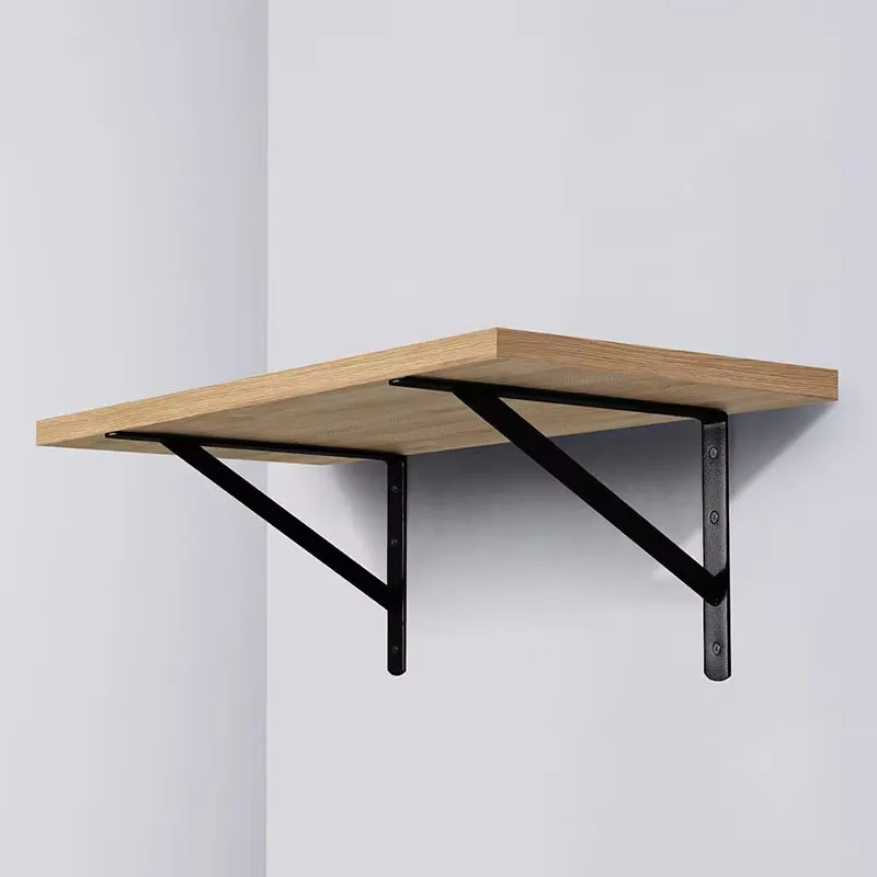 A timber shelf carried on two black steel tripod brackets