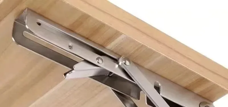 A stainless steel folding bracket locked out beneath a timber worktop
