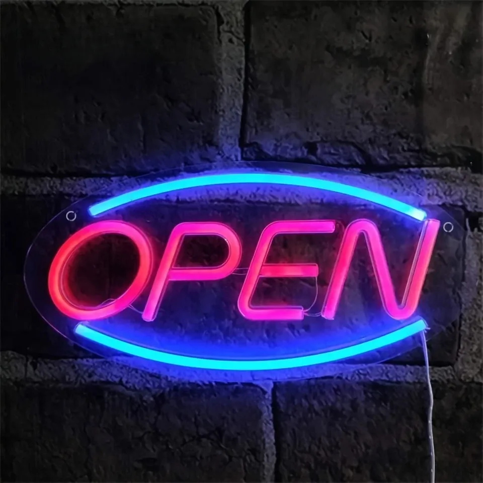An OPEN neon sign in blue and pink mounted on a brick wall